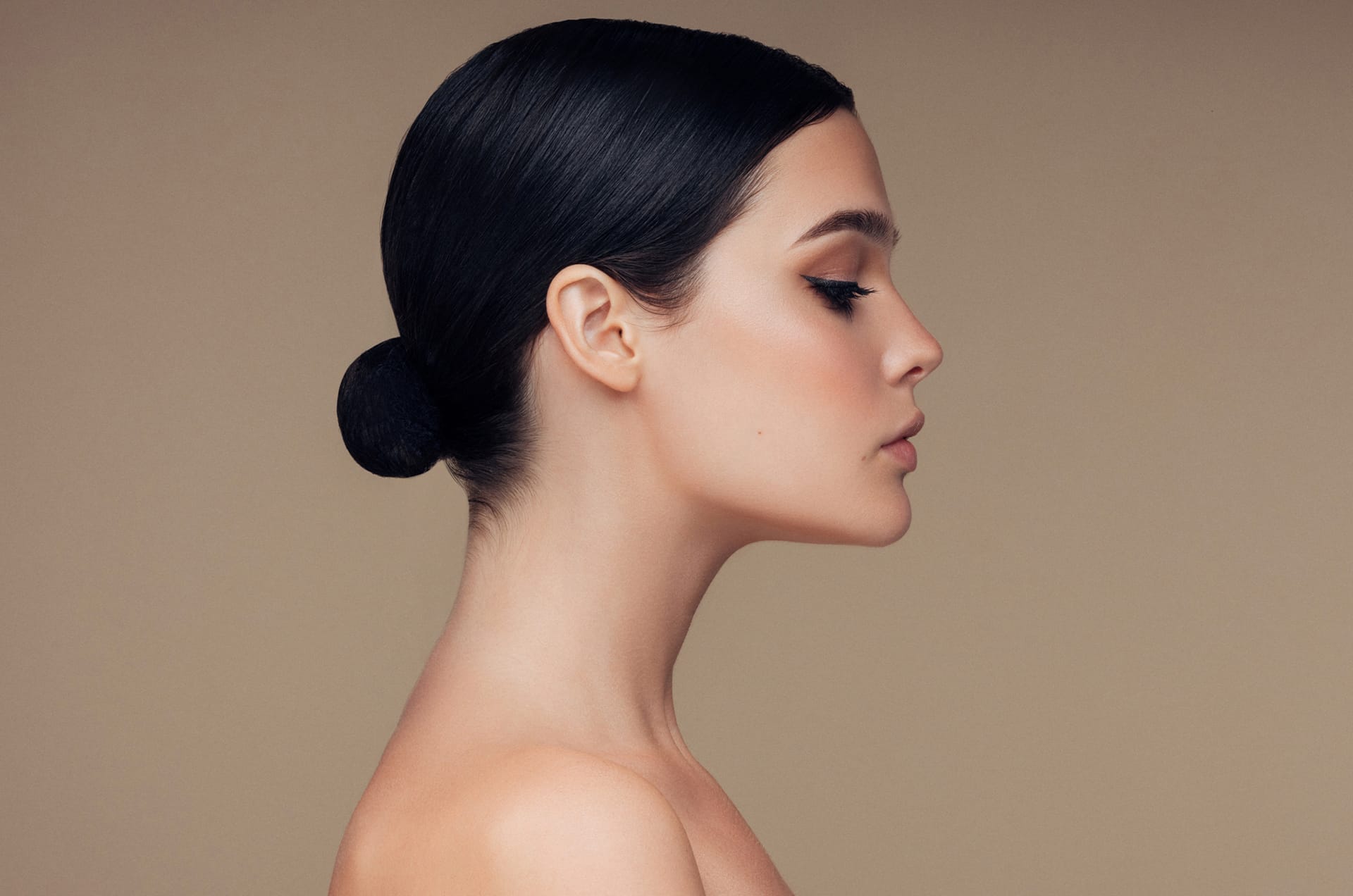 Woman with her hair in a bun looking to the side